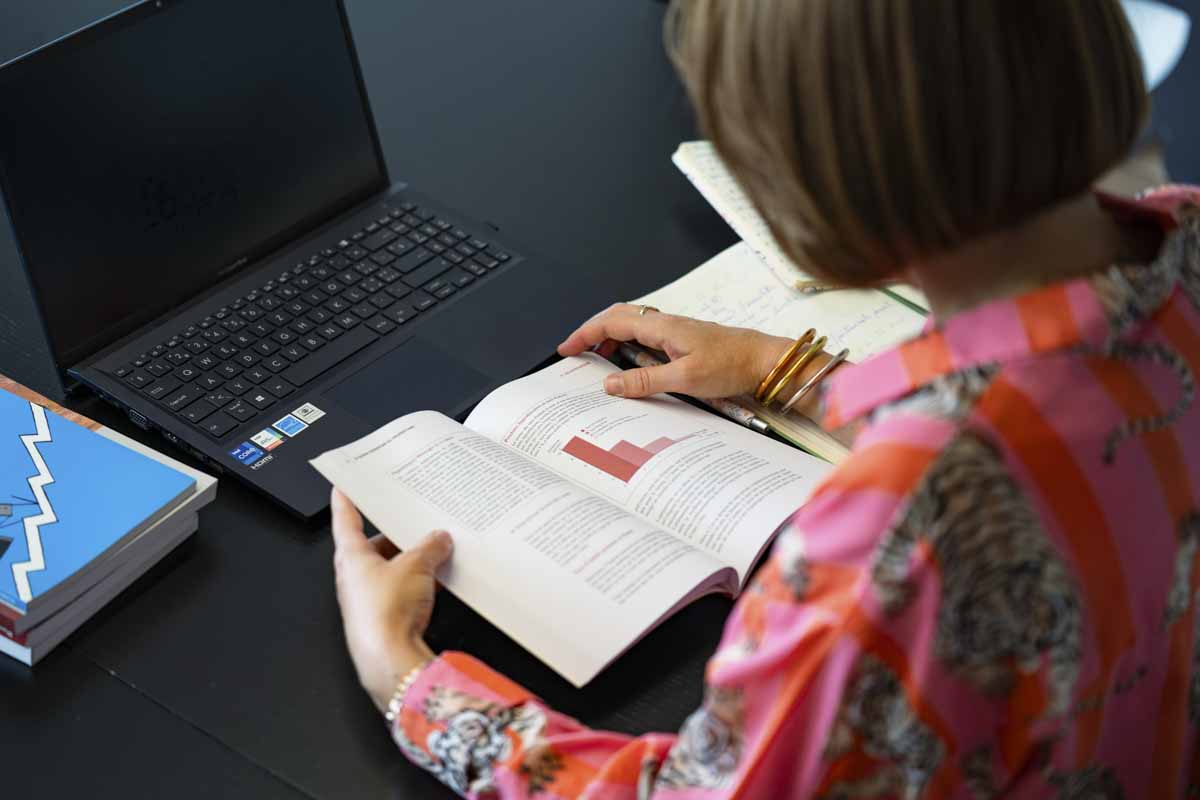 Marine Fuentes étudiant un document financier pour préparer une stratégie patrimoniale